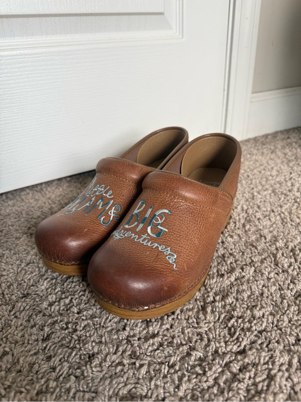Women's Dansko Brown Leather Slip-On Clogs with Blue Accent Text